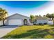 Charming one-story home with a manicured lawn, attached garage, and delightful palm trees at 10733 Drummond Rd, Tampa, FL 33615