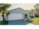 Inviting single-story home with a garage, quaint front yard, and fresh landscaping details at 10733 Drummond Rd, Tampa, FL 33615