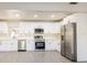 Updated kitchen with stainless appliances, white cabinetry, and a long countertops for meal preparation at 10733 Drummond Rd, Tampa, FL 33615