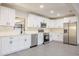 Modern kitchen with white cabinets, stainless steel appliances, and light grey wood-look floors at 10733 Drummond Rd, Tampa, FL 33615
