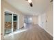 Large living room with wood-look floors leading to a sunroom, entryway, and bedroom doors at 10733 Drummond Rd, Tampa, FL 33615