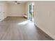 Spacious living room with wood-look flooring, leading to a sunroom with sliding glass doors at 10733 Drummond Rd, Tampa, FL 33615
