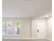 Bright living room with clean walls, three windows with great curb appeal, and a white entry door at 10733 Drummond Rd, Tampa, FL 33615