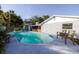 Backyard pool featuring seating space and lush tropical landscaping at 10733 Drummond Rd, Tampa, FL 33615