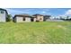 Large backyard featuring lush green grass, sliding glass doors, and a neighboring fence at 11121 Hudson Hills Ln, Riverview, FL 33579