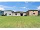 Spacious backyard featuring a well-maintained lawn, sliding glass door, and neighboring properties at 11121 Hudson Hills Ln, Riverview, FL 33579