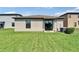 Well-maintained backyard featuring a lush lawn and sliding glass door, offering outdoor living at 11121 Hudson Hills Ln, Riverview, FL 33579