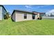 Spacious backyard featuring a well-maintained lawn, sliding glass door, and a neighboring fence at 11121 Hudson Hills Ln, Riverview, FL 33579