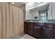 Double sink bathroom featuring dual sinks, granite countertops, and a shower with curtain at 11121 Hudson Hills Ln, Riverview, FL 33579