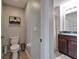 Cozy half bathroom with neutral paint, a wood vanity, and toilet at 11121 Hudson Hills Ln, Riverview, FL 33579