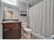 Well-lit bathroom featuring vanity with granite counters and a shower with a striped shower curtain at 11121 Hudson Hills Ln, Riverview, FL 33579