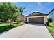 Home features a well-kept lawn, and long driveway, and an attached two-car garage at 11121 Hudson Hills Ln, Riverview, FL 33579