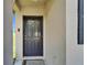 Close-up of a charming front door featuring a welcome mat and neutral colored stucco walls at 11121 Hudson Hills Ln, Riverview, FL 33579