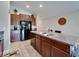 Kitchen featuring an island, granite countertops, wooden cabinets, stainless steel appliances and a clock at 11121 Hudson Hills Ln, Riverview, FL 33579