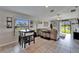 Living room featuring tile floors, large windows, a ceiling fan, and a sliding glass door to the backyard at 11121 Hudson Hills Ln, Riverview, FL 33579