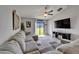 Living room showcasing a ceiling fan, large couch, and a view of the outdoor scenery through sliding glass doors at 11121 Hudson Hills Ln, Riverview, FL 33579