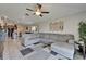 Open-concept living area with tile flooring, a large sectional sofa, and easy access to the kitchen and dining space at 11121 Hudson Hills Ln, Riverview, FL 33579