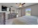 Bright main bedroom featuring a view of the pond, ceiling fan, and gray carpet at 11121 Hudson Hills Ln, Riverview, FL 33579