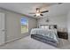 Sunlit main bedroom featuring a large window, a ceiling fan, and gray carpet at 11121 Hudson Hills Ln, Riverview, FL 33579