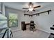 Office with natural light, floating shelves, and a black rolling chair at 11121 Hudson Hills Ln, Riverview, FL 33579