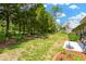 Expansive backyard featuring a patio, well-manicured lawn, beautiful landscaping, and a peaceful wooded view at 11148 Hollander Ave, Hudson, FL 34667