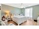 Cozy bedroom features wood floors, a ceiling fan, and natural light from the window with white curtains at 11148 Hollander Ave, Hudson, FL 34667