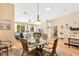 Open-concept dining area adjacent to the living room, features a modern chandelier and seating for four at 11148 Hollander Ave, Hudson, FL 34667