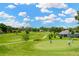 Scenic view of golfers on a lush green golf course under a bright blue sky with scattered clouds at 11148 Hollander Ave, Hudson, FL 34667