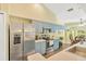 Well-lit kitchen featuring stainless steel appliances, light blue cabinets, and stylish countertops at 11148 Hollander Ave, Hudson, FL 34667