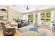 Bright living area with large windows, hardwood floors, and comfortable seating options at 11148 Hollander Ave, Hudson, FL 34667