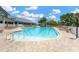 Relaxing community pool area with lounge chairs and umbrellas for residents to enjoy under sunny skies at 11148 Hollander Ave, Hudson, FL 34667