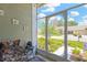 Relaxing screened porch with comfortable seating and a view of the front yard at 11148 Hollander Ave, Hudson, FL 34667
