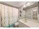 Bright bathroom featuring a shower-tub combination with a tasteful decorative shower curtain at 12300 Vonn Rd # 7107, Largo, FL 33774