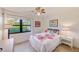 Comfortable bedroom with beautiful floral bedding, tiled floors, and a window view of the exterior at 12300 Vonn Rd # 7107, Largo, FL 33774