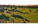 Scenic golf course view with lush green grass, mature trees, and tranquil water feature at sunset at 12300 Vonn Rd # 7107, Largo, FL 33774