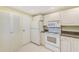 Well-maintained kitchen with white appliances, tiled floor, and ample storage space for cooking essentials at 12300 Vonn Rd # 7107, Largo, FL 33774
