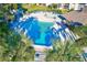 Overhead view of a pristine pool with lounge chairs and verdant tropical landscaping at 12300 Vonn Rd # 7107, Largo, FL 33774
