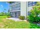 Spacious screened patio with view of grassy lawn is surrounded by flowering shrubs at 12300 Vonn Rd # 7107, Largo, FL 33774