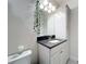 Bathroom with white cabinets and a granite countertop, decorative plant hanging on mirror, and white rose on toilet at 13706 Osprey Fern Ln, Riverview, FL 33569