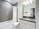 Bathroom featuring a shower with gray tiling, a white shower curtain, and a vanity with a dark countertop at 13706 Osprey Fern Ln, Riverview, FL 33569