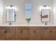 Elegant bathroom featuring dual sinks, wood cabinets, two rectangular mirrors, and shiplap walls at 13706 Osprey Fern Ln, Riverview, FL 33569