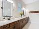 Elegant bathroom featuring dual sinks, wood cabinets, and a decorative vase with floral arrangement at 13706 Osprey Fern Ln, Riverview, FL 33569