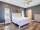 Spacious bedroom featuring a stylish ceiling fan, wood floors, and decorative window pane accents at 13706 Osprey Fern Ln, Riverview, FL 33569
