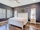 Charming bedroom featuring three accent window frames, a ceiling fan, and hardwood flooring at 13706 Osprey Fern Ln, Riverview, FL 33569
