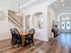 Elegant dining area with a wooden table, black chairs, a chandelier, and views of the hallway at 13706 Osprey Fern Ln, Riverview, FL 33569