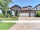 Charming single-Gathering home with a stone facade, tile roof, and well-manicured landscaping at 13706 Osprey Fern Ln, Riverview, FL 33569