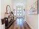 Inviting hallway featuring wood floors, stylish decor, and a view of the front doors at 13706 Osprey Fern Ln, Riverview, FL 33569