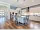 Open kitchen with white cabinets, stainless steel appliances, a center island, and wood flooring at 13706 Osprey Fern Ln, Riverview, FL 33569