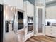 Modern kitchen with stainless steel refrigerator and appliances, white cabinetry, and pantry at 13706 Osprey Fern Ln, Riverview, FL 33569