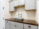 Laundry room boasting a wood countertop, updated cabinetry, and modern finishes at 13706 Osprey Fern Ln, Riverview, FL 33569